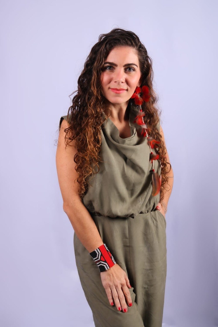 Flávia Maitri sorrindo em pose de retrato três quartos