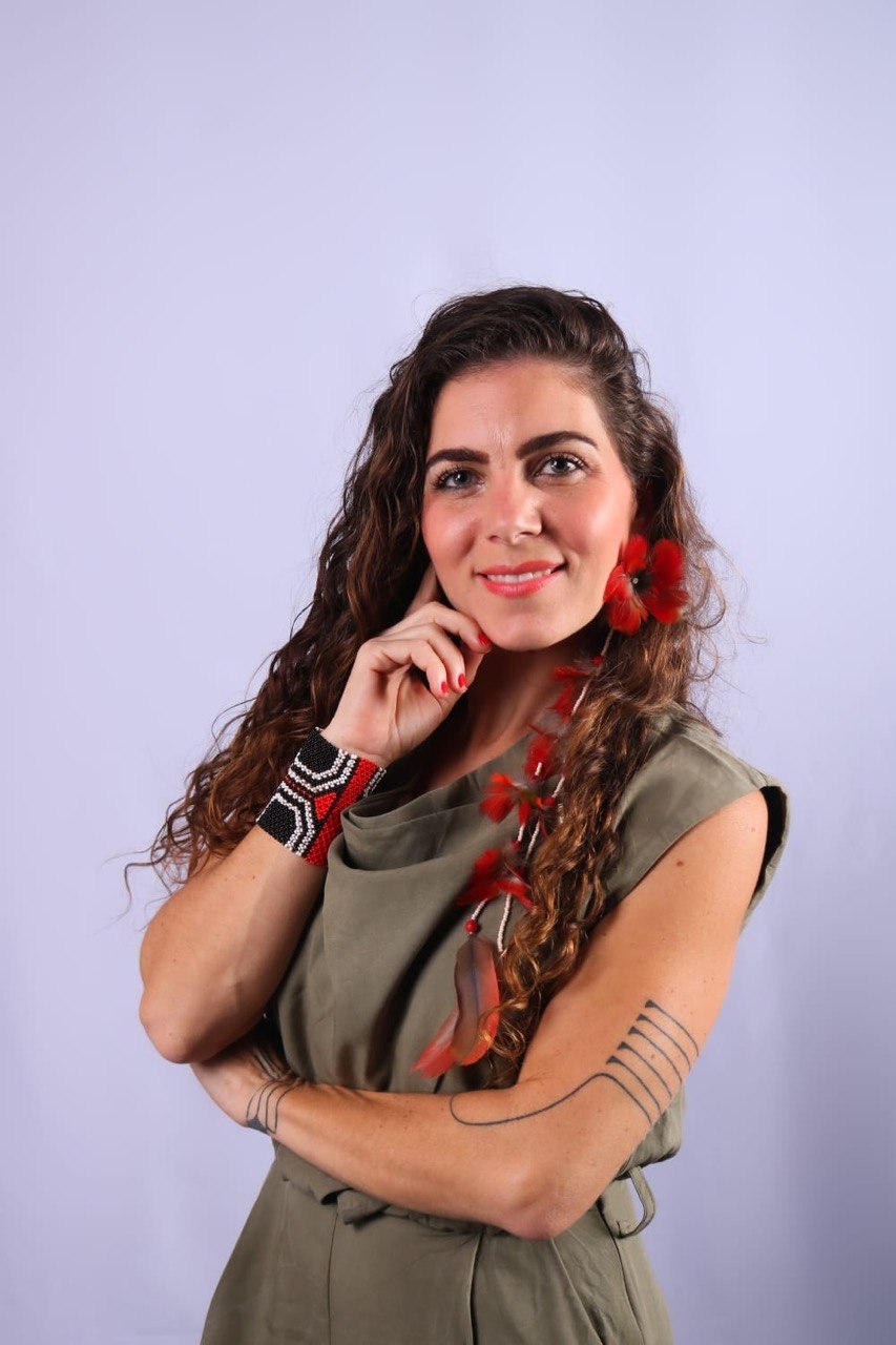 Flávia Maitri em retrato de meio corpo, sorriso aberto